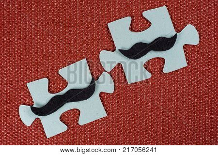 Close-up of two parts of a puzzle. Symbolic men with a mustache. The concept of psychological compatibility, friendship.