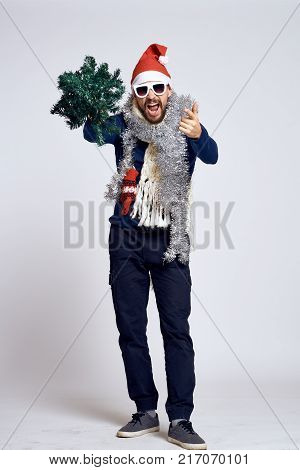 man is standing at full height, party, artificial Christmas tree, tinsel, new year.