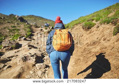 back view of woman traveler on a walk in the Valley of the river of Hveragerdi Iceland. Hiking Tour of Reykjadalur Hot Springs