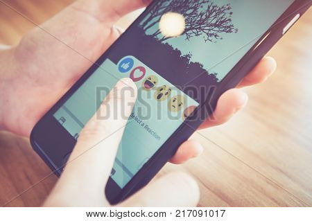 Bangkok Thailand - Decamber 07, 2017 : hand is pressing the Facebook screen on apple iphone6 Social media are using for information sharing and networking.