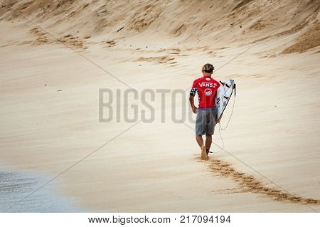 SUNSET BEACH HAWAII USA - DECEMBER 2, 2017: Pro surfer walking down the beach at the 2017 Vans World Cup of Surfing competition at Sunset Beach on Oahu's scenic North Shore. This is the second of three surfing competitions and Conner Coffin.