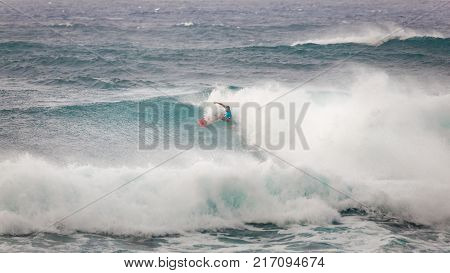 SUNSET BEACH HAWAII USA - DECEMBER 2, 2017: Competitive surfer at the 2017 Vans World Cup of Surfing competition at Sunset Beach on Oahu's scenic North Shore. This is the second of three surfing competitions and Conner Coffin took first place.