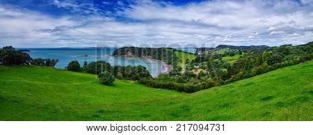Panoramatic view of amazing nature in New Zealand. Green meadow cliff and beach.