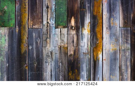 Abstract background of old worn wooden boards of different colors close up