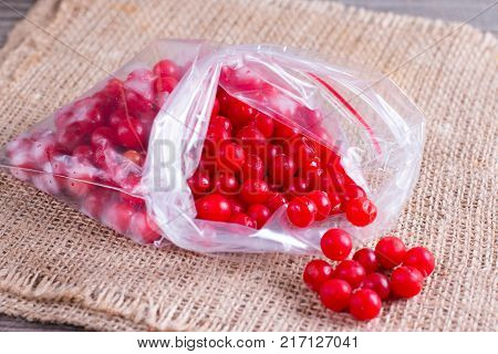 Frozen berries of a viburnum in a bag on a table