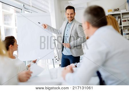 Business plan explained on flipchart by CEO to employees