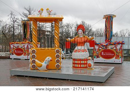 Moscow Russia - February 27 2017: Traditional Dymkovo toy woman with a yoke and buckets near well and birds as art object at Russian national festival 
