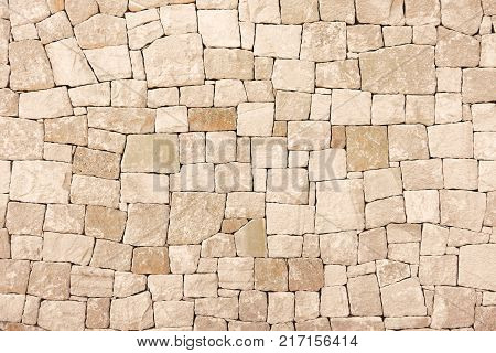 Masonry wall of colors stones with irregular pattern texture background