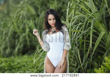 Beautiful young girl in a sexy white swimsuit on the beach