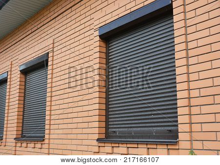 Brick House Windows with rolling shutter for house protection.