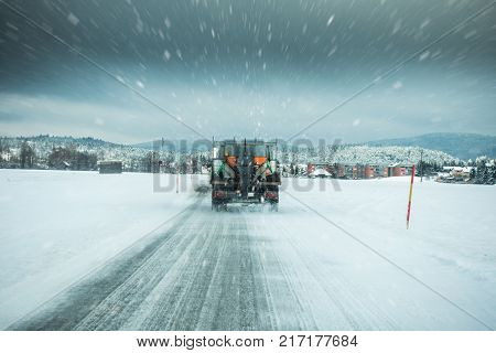 Winter Service Truck Or Gritter Spreading Salt On The Road Surface To Prevent Icing In Stormy Snow W