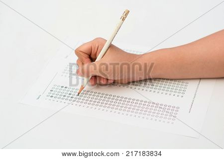 woman's hands filling in standardized test form