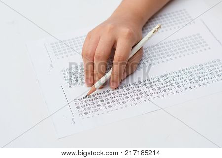 woman's hands filling in standardized test form