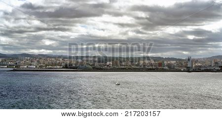 Panoramic view of the city of La Coruna on the Atlantic coast of Galicia (Spain). Sky with dark clouds and sun reflections