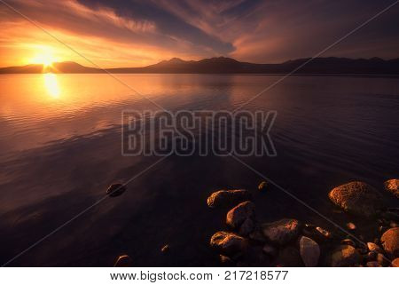 Amazing sunset by the lake. Colorful sky with beautiful clouds.