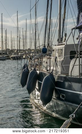 sailboat, protection balls, sports marina area, Copy Space, background blurred of other ship docked sunset scene Nautical detail