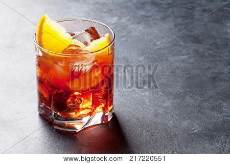 Negroni cocktail on dark stone table. With space for your text
