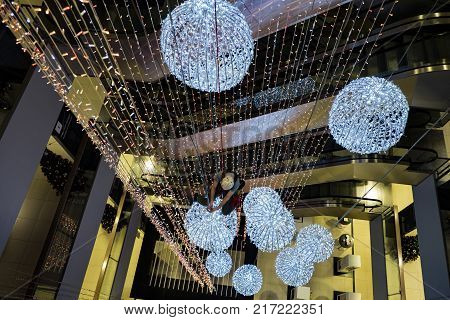 industrial climber sets up Christmas decorations in the shopping centre