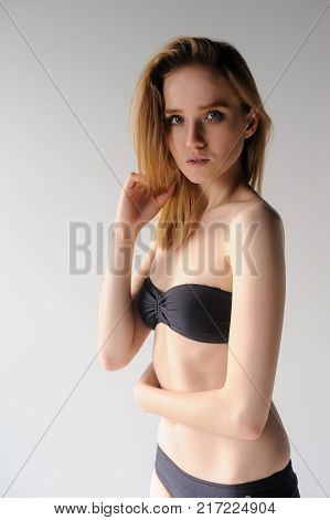 Young beautiful fashionable deplorable model in black lingerie over white background
