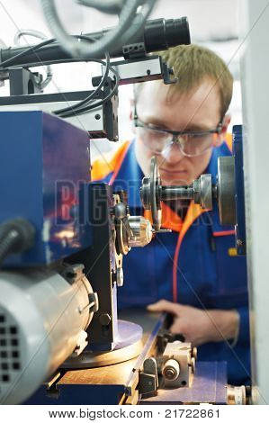Closeup Arbeiter in einheitliche und schützende Gläser arbeiten auf Schärfen Werkzeugmaschine