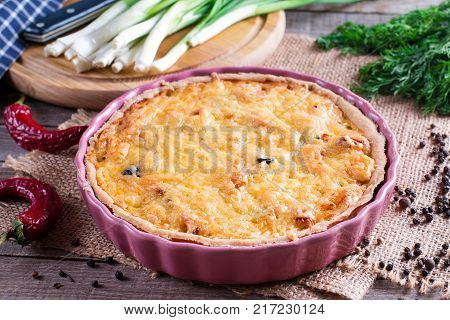 Traditional french quiche pie with chicken and mushroom on wooden table. Horizontal