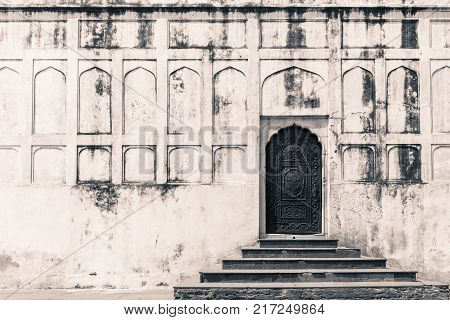 Front picture of white wall with Mughal Indian Style with black door inside Red Fort landmark of New Delhi located in India.