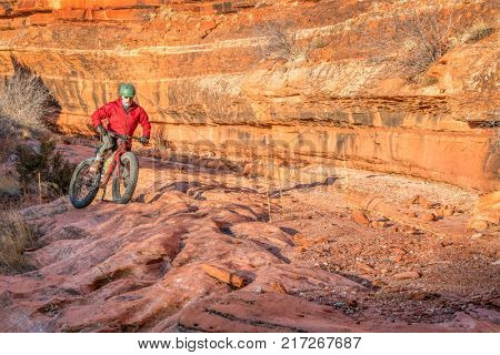riding a fat mountain bike on a slickrock at the sandstone canyon bottom - Ruby Wash in Red Mountain Open Space north of Fort Collins, Colorado