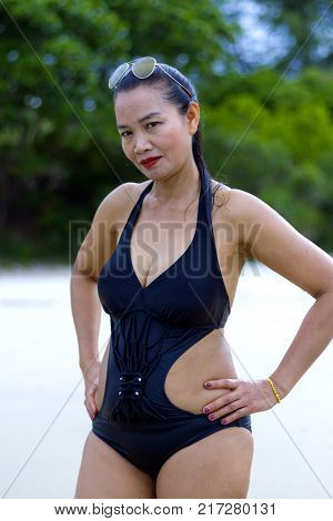 Woman black bikini show shape sexy symbol on beach at Ban Krut Beach Prachuap Khirikhan Province Thailand