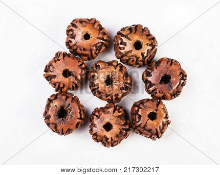 top view of beads from natural seeds of Rudraksha tree on gray concrete background
