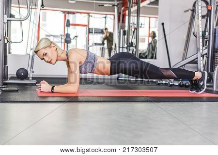 young sportive woman doing hyperextension exercise on gym machine