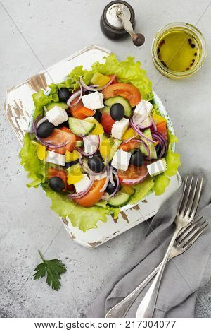 Greek salad in ceramic plate on gray concrete background. Traditional Greek dish. Selective focus.Top view.
