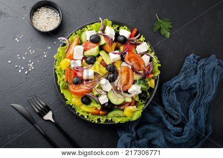 Greek salad in ceramic plate on gray concrete background. Traditional Greek dish. Selective focus.Top view.