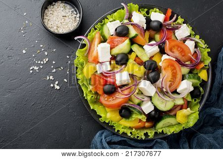Greek salad in ceramic plate on gray concrete background. Traditional Greek dish. Selective focus.Top view.