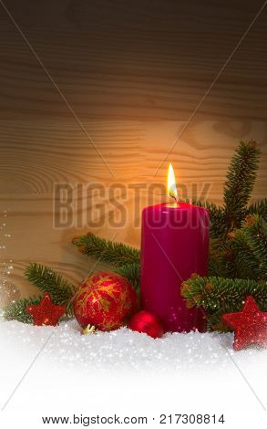 Avent candle and christmas decoration isolated on wood background. Christmas background with snow, candle and red stars.