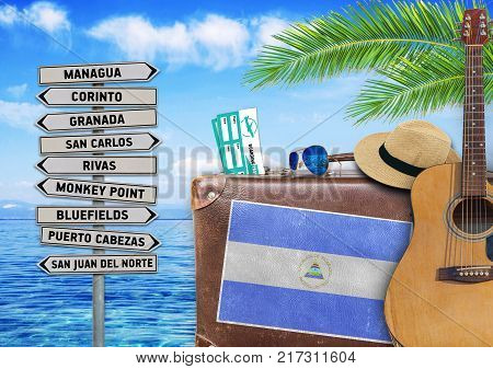 Concept of summer traveling with old suitcase and Nicaragua town sign