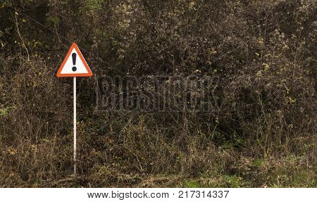 sign with an exclamation point on the side of the road