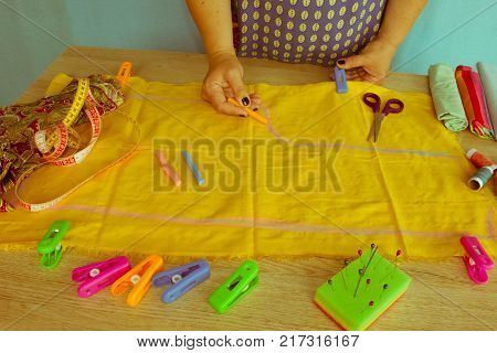 closeup of woman hands sewing yellow cloth outdoors. Woman's Hand Sewing Quilt