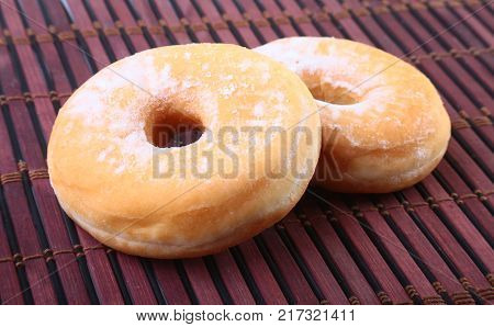 Homemade Doughnuts with Jelly filled and powdered sugar on Bamboo tablecloth. Selective focus