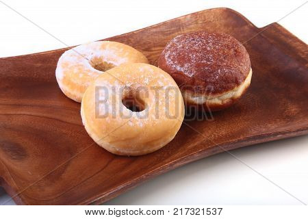 Assorted Homemade Doughnuts with Jelly filled and powdered sugar on wooden salver. Selective focus
