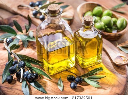 Olive oil and berries are on the olive wooden tray.