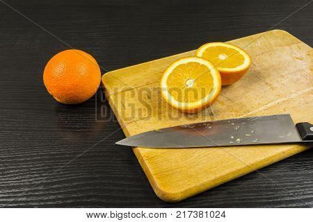 Cut an orange knife in half on a chopping board.