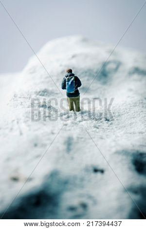 a miniature hikker in a snowcapped mountain on winter time