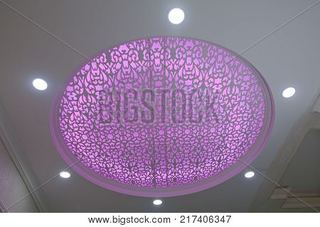 Modern layered ceiling with embedded lights and stretched ceiling inlay, light turned on Luxury apartment interior with modern ceiling lights