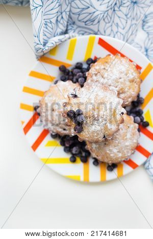 Blueberry muffins on plate and bright floral cloth