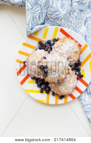 Blueberry muffins on plate and bright floral napkin, close-up