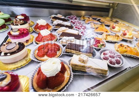 Lots of colorful and tasteful cakes in a patisserie shop delicious cakes