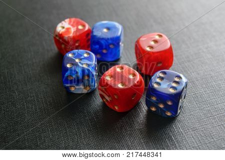 multi-colored dice lying on a black textured surface