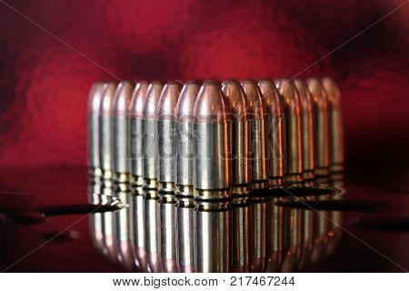Bullets in formation on reflective surface with copper glow background