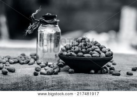 [arachis Hypogaea] Raw Groundnut In A Clay Bowl With Groundnut Oil On A Gunny Background.;