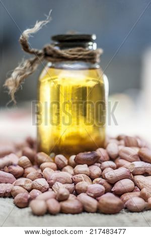 [arachis Hypogaea] Raw Groundnut In A Clay Bowl With Groundnut Oil On A Gunny Background.;